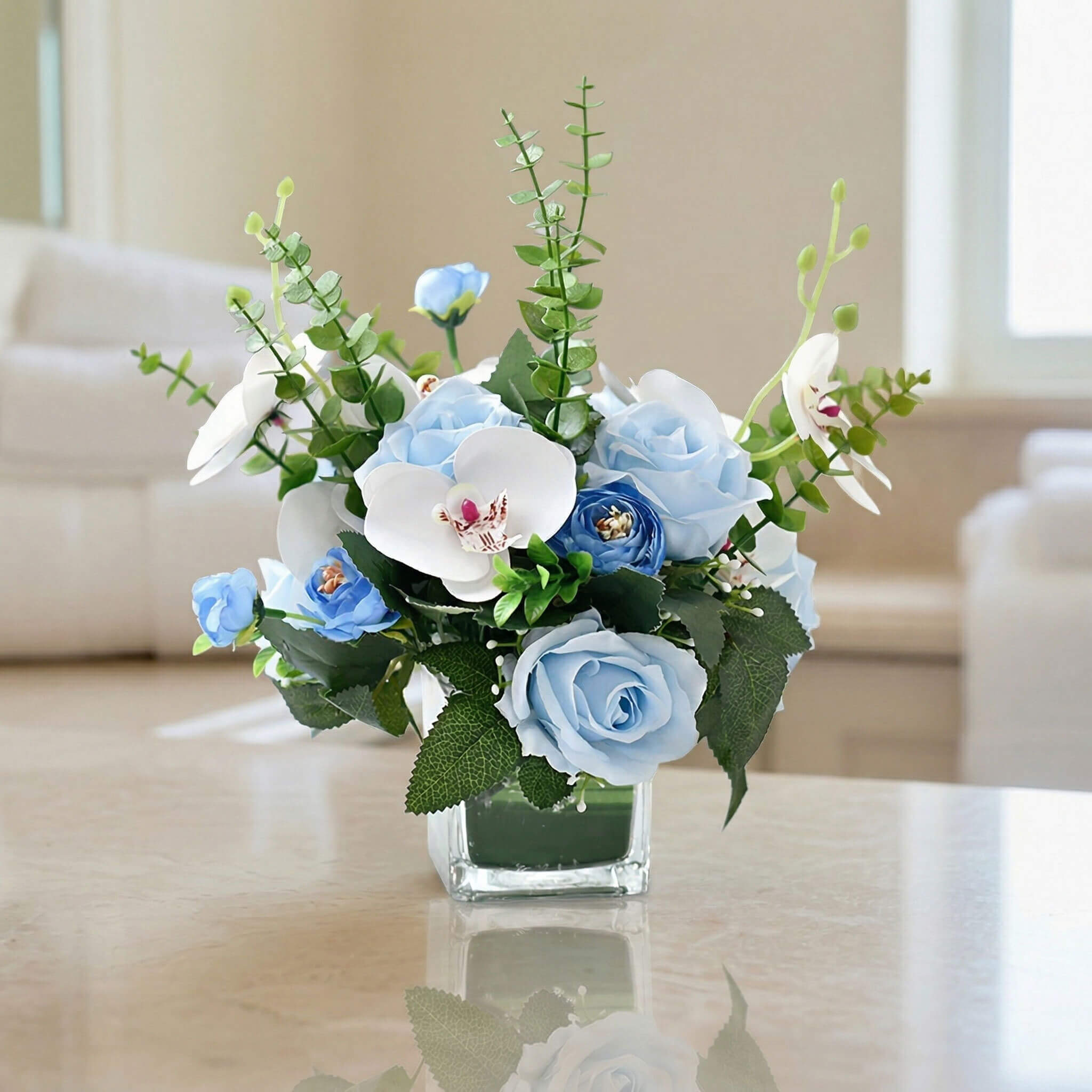Blue faux orchid and rose floral centerpiece with eucalyptus, suitable for modern room styling