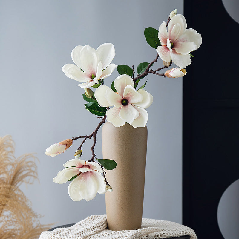 Real touch artificial magnolia arrangement in a pale yellow vase, elegant tall floral centerpiece for refined home decor.