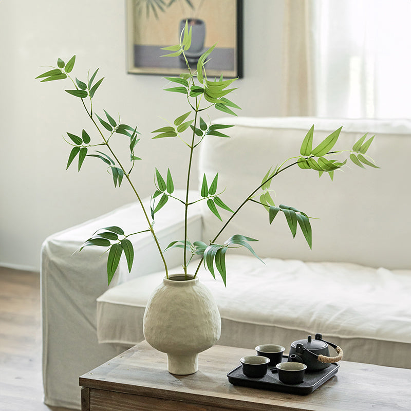 Artificial bamboo plant in ceramic vase styled on a side table for minimalist home decor