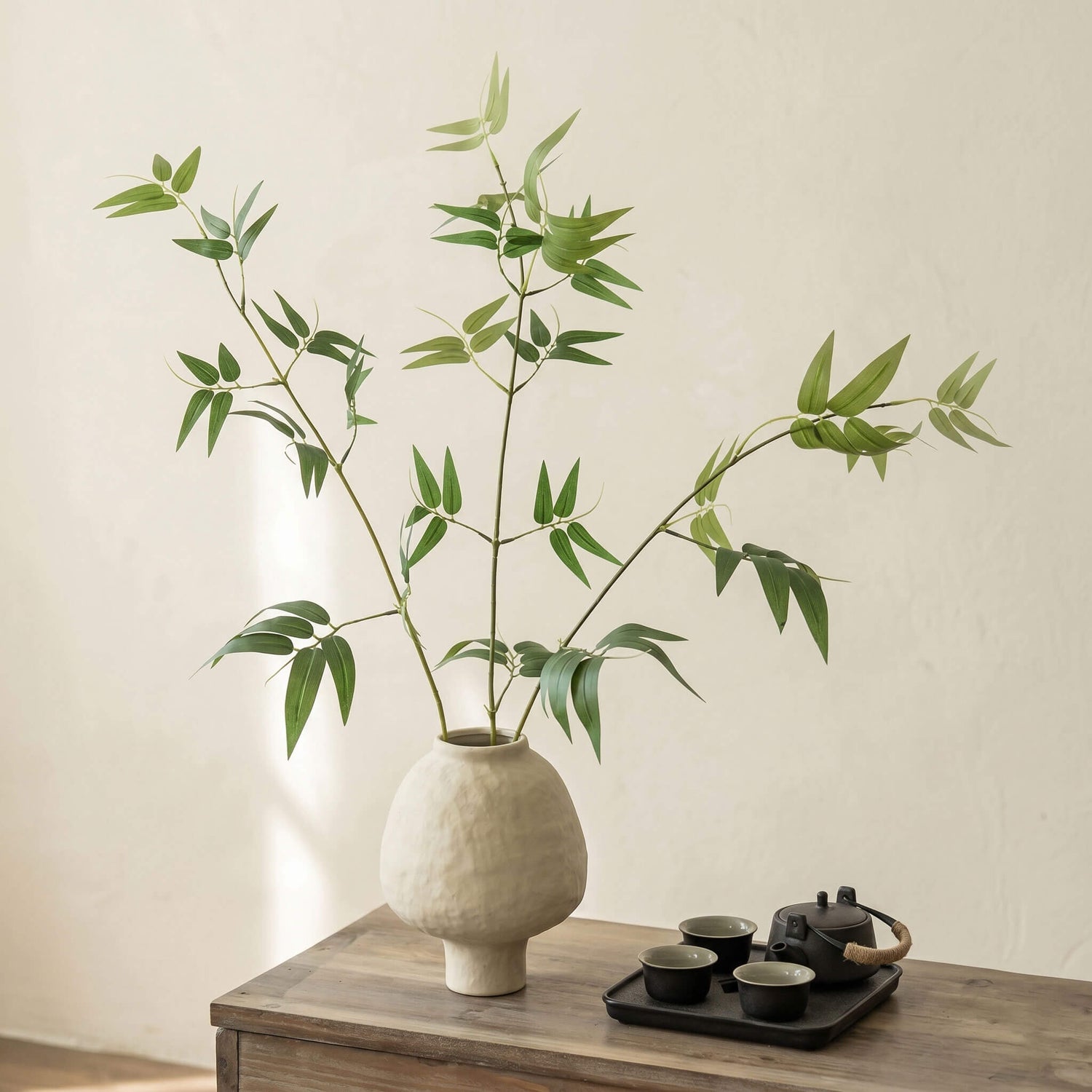 Artificial bamboo plant in ceramic vase styled on a side table for minimalist home decor