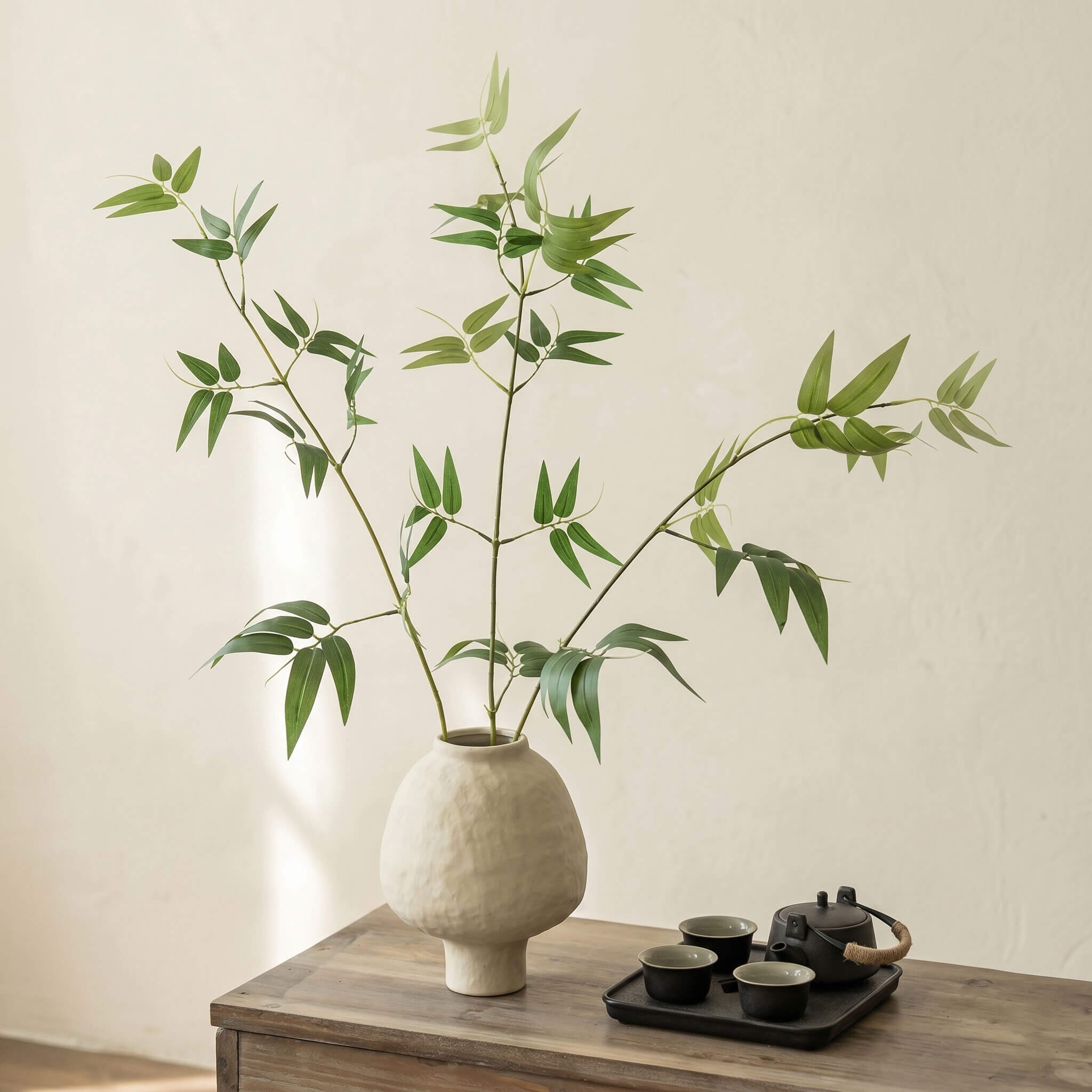 Artificial bamboo plant in ceramic vase styled on a side table for minimalist home decor