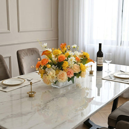 Faux calla lily and rose flower centerpiece with eucalyptus decorating a dining table