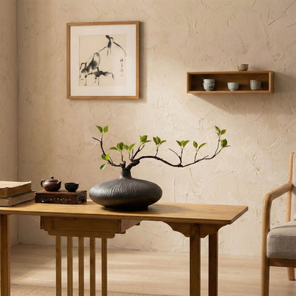 Faux ficus branch in ceramic vase enhancing a serene tea room with natural minimalist decor