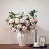 Artificial hydrangea arrangement featuring soft pink blooms arranged in a white ceramic vase, creating an elegant floral centerpiece for home decor.