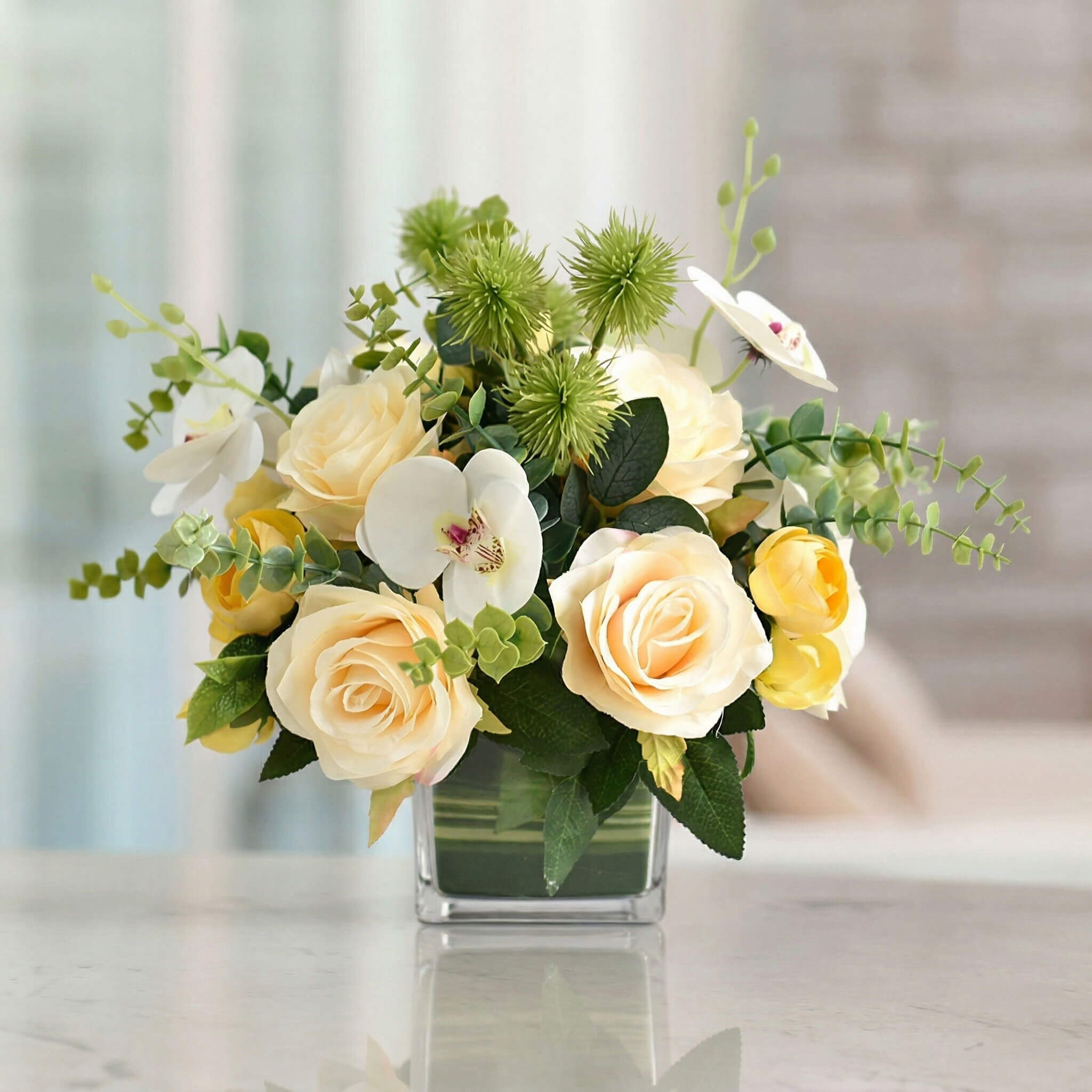 Champagne artificial orchid and rose floral centerpiece with eucalyptus