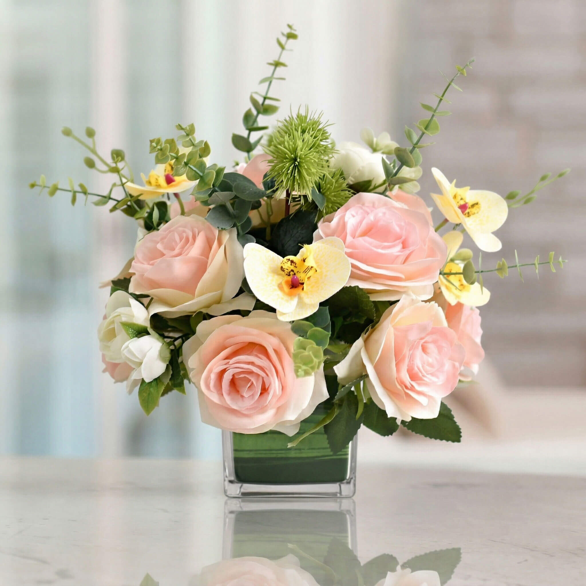 Pink artificial orchid and rose flower arrangement with eucalyptus