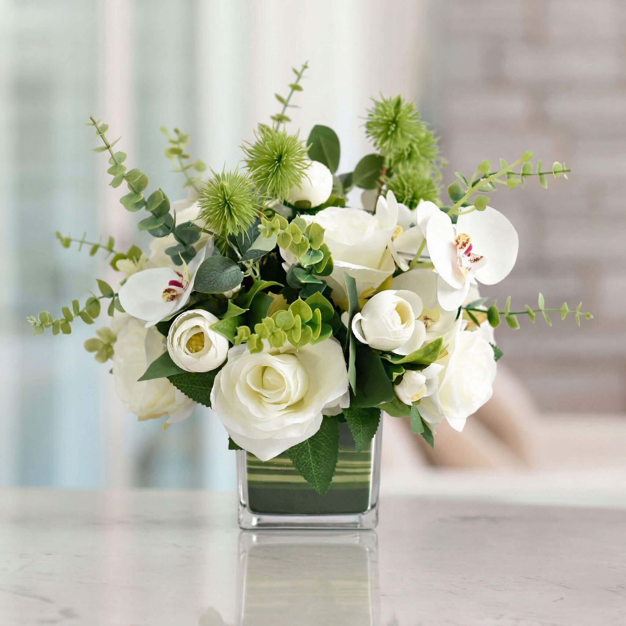 White artificial orchid and rose flower centerpiece with eucalyptus