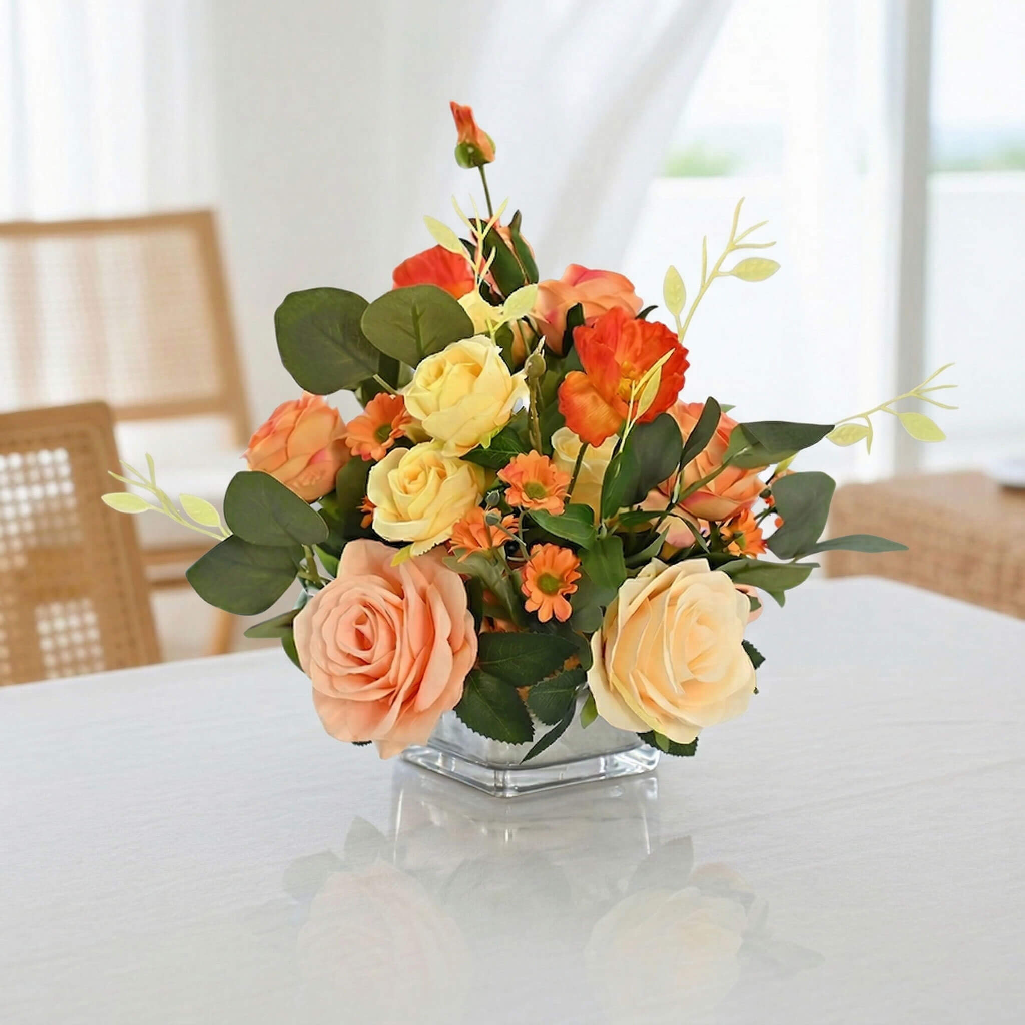 Orange artificial peony and rose flower arrangement on a living room coffee table