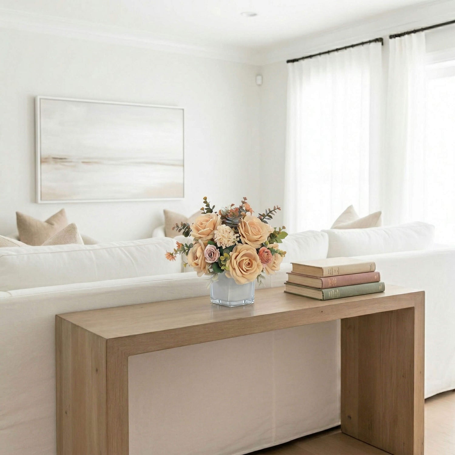 Artificial rose and hydrangea floral arrangement with eucalyptus on a sofa console table