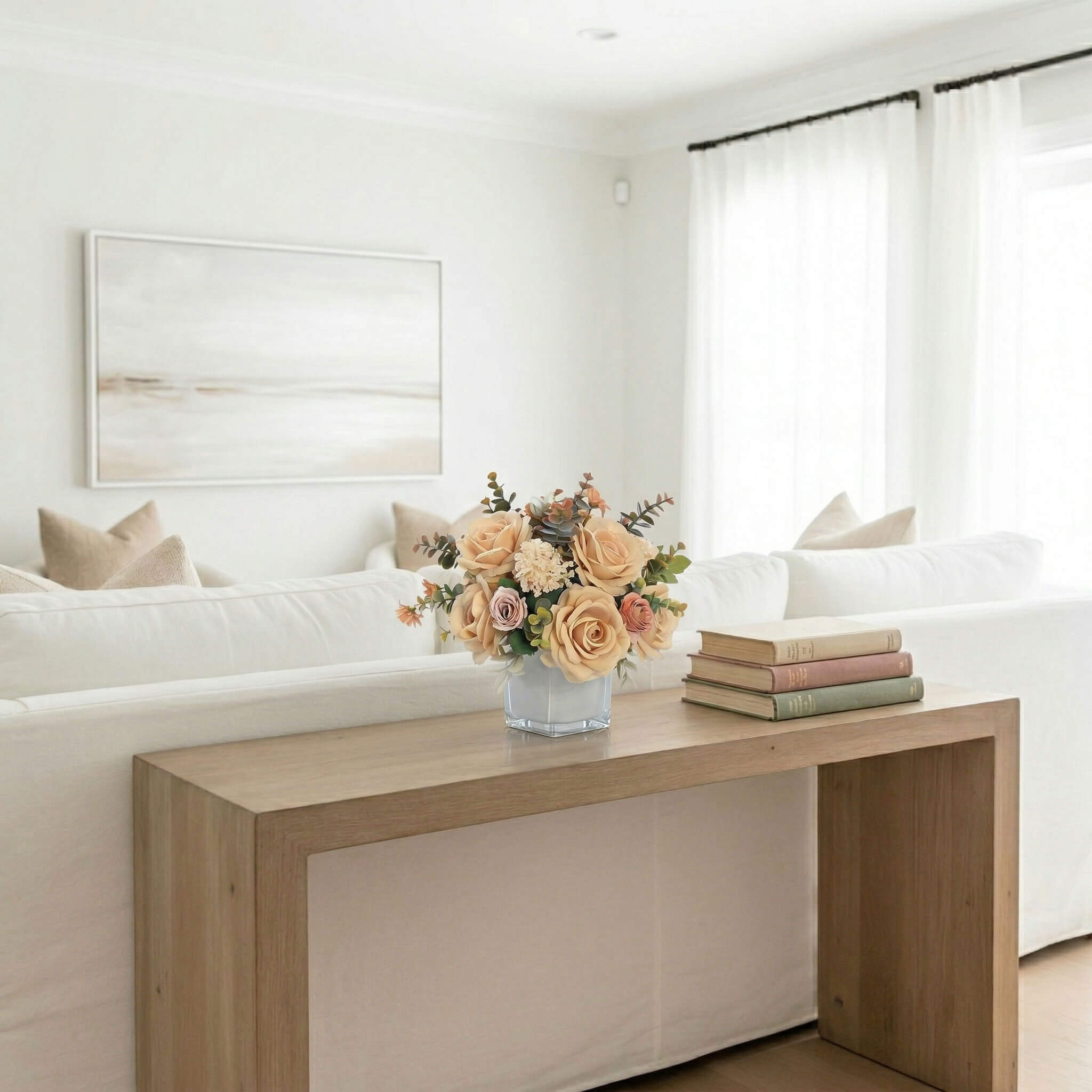 Artificial rose and hydrangea floral arrangement with eucalyptus on a sofa console table
