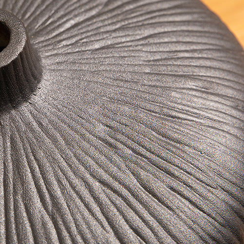 Detail of black glazed ceramic vase used for artificial ficus plant arrangement