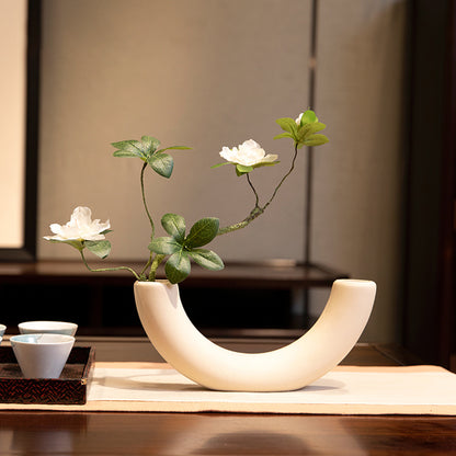 Silk azalea arrangement in a white semicircular vase, a compact and elegant accent for modern home decor.
