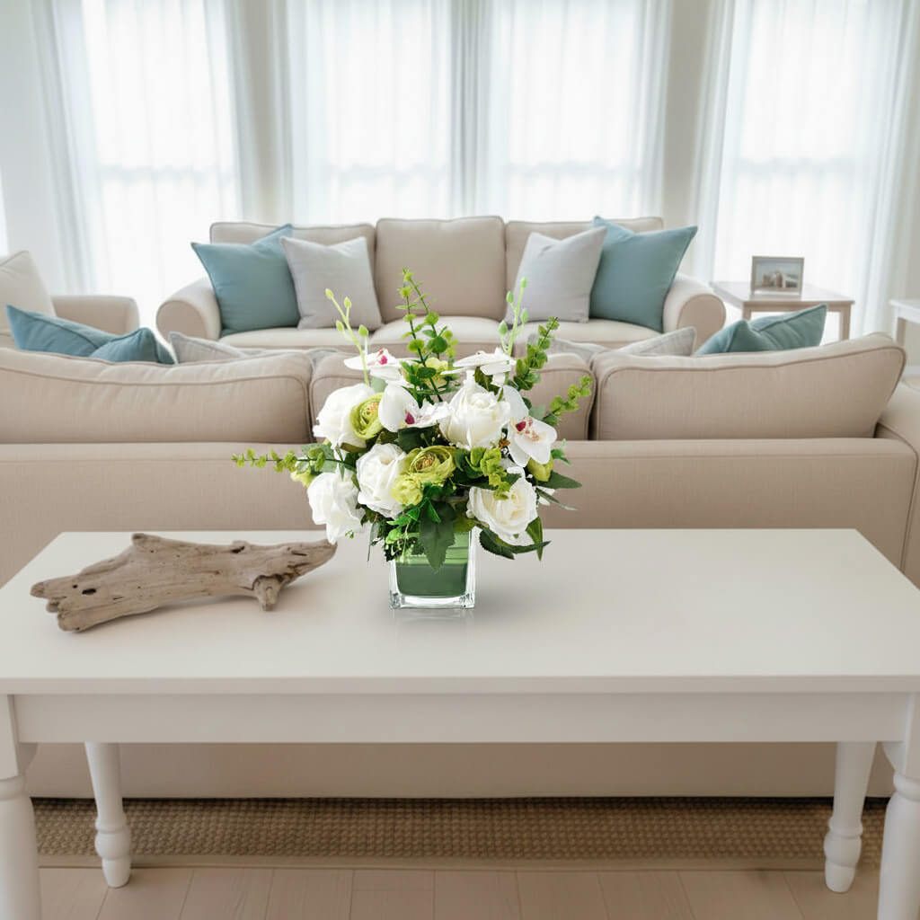 White faux orchid and rose centerpiece with eucalyptus on a living room console table