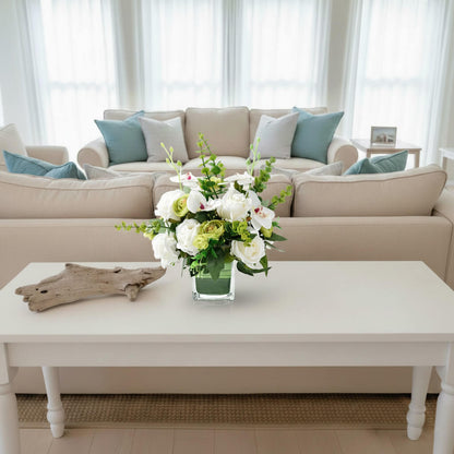 White faux orchid and rose centerpiece with eucalyptus on a living room console table