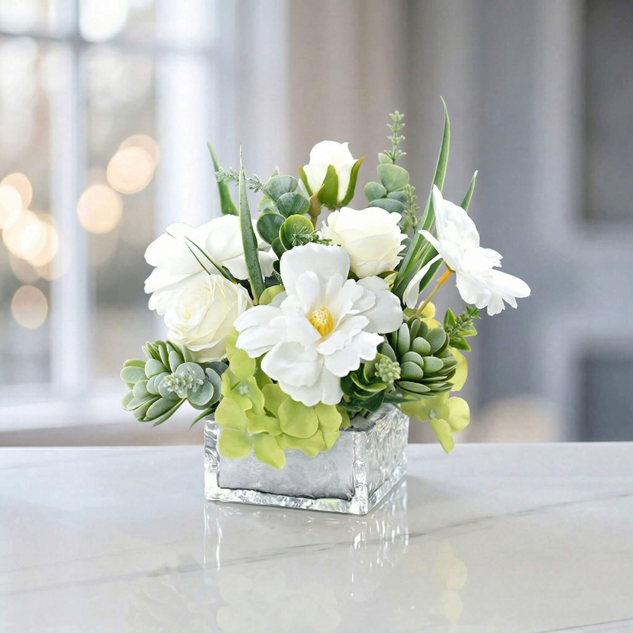 White faux rose and hydrangea floral centerpiece with succulent