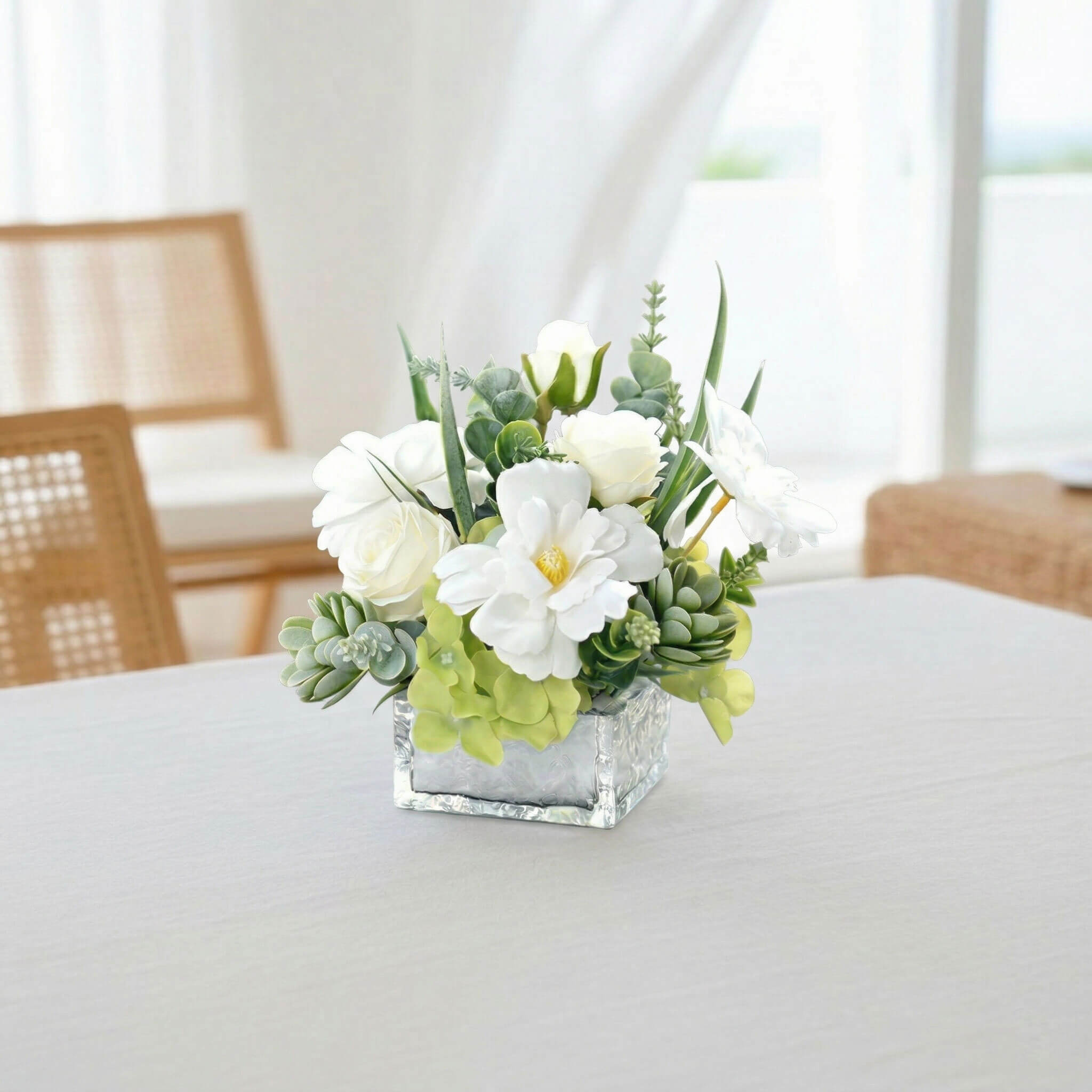 White faux rose and hydrangea floral centerpiece with succulent on a living room coffee table