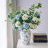 Artificial hydrangea arrangement in a blue and white porcelain vase, elegant faux floral centerpiece for home decor.