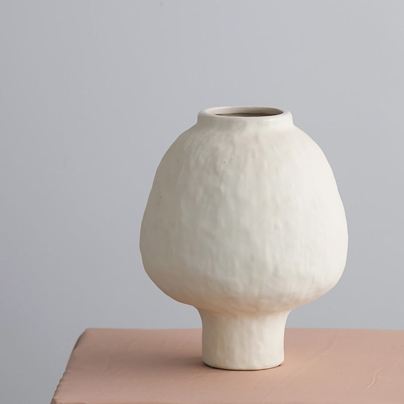 Ivory ceramic vase detail used for artificial bamboo plant arrangement with clean minimalist finish