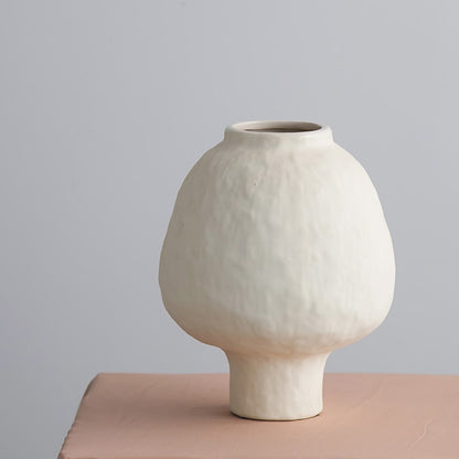 Ivory ceramic vase detail used for artificial bamboo plant arrangement with clean minimalist finish