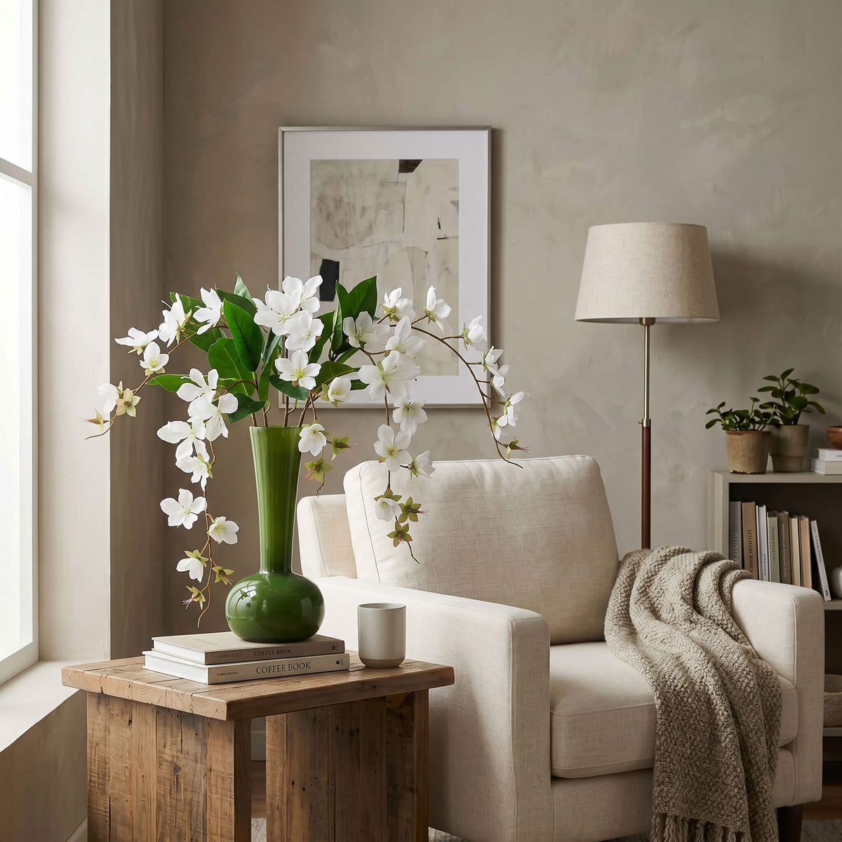 Artificial jasmine arrangement styled in a living room, placed on a coffee table with an olive green vase for a fresh natural touch.