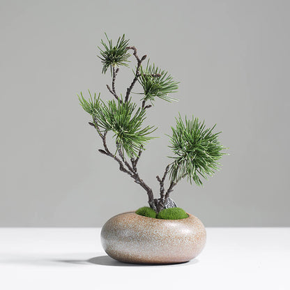 Minimalist artificial pine tree in brown ceramic vase styled on a side table for modern home decor