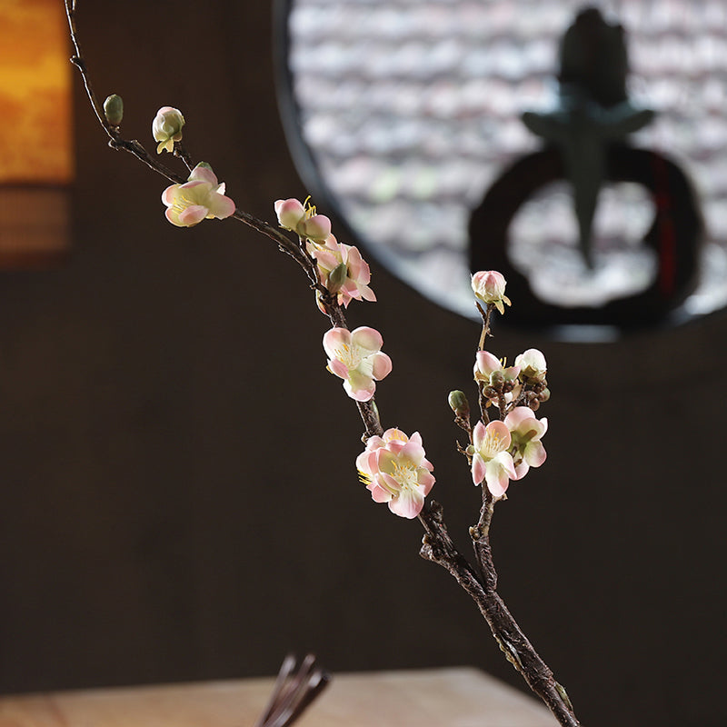 Front-facing view of pink artificial plum blossoms with soft hues and layered petal detail.