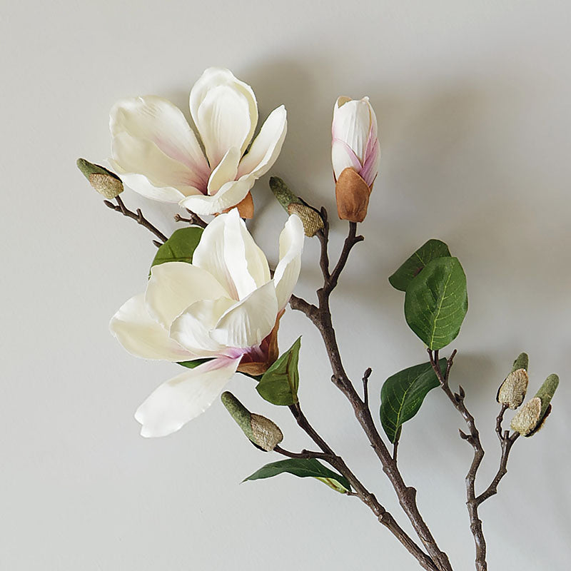 Close-up of real touch artificial magnolia bloom, showcasing soft white petals and lifelike floral texture.