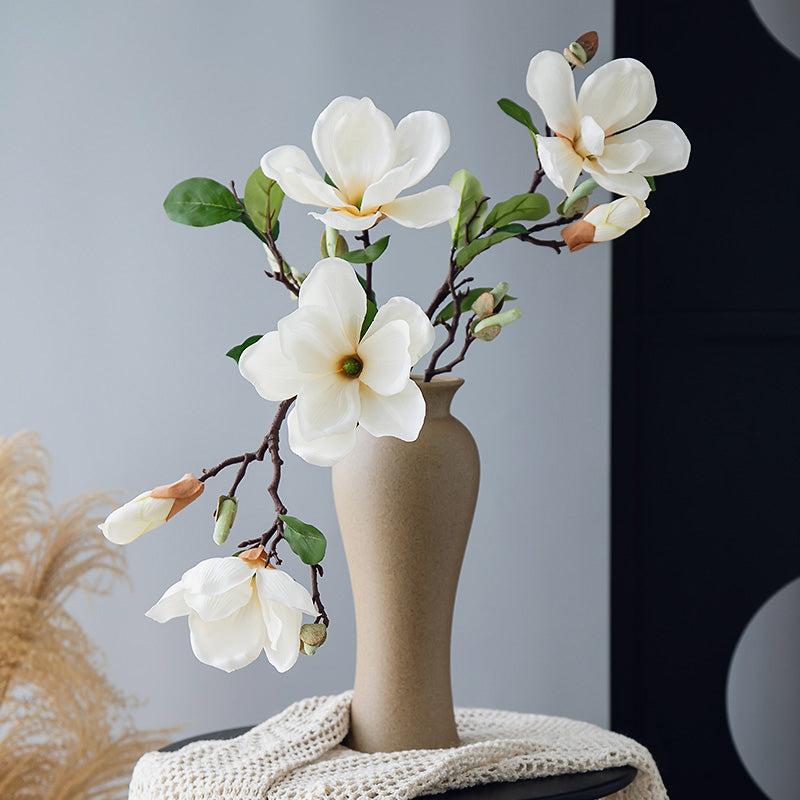 Real touch faux magnolia arrangement in a curved pale yellow vase, tall and elegant floral decor for modern interiors.