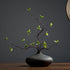 A faux multi-branched ficus branch in a black glazed ceramic vase (21.6&