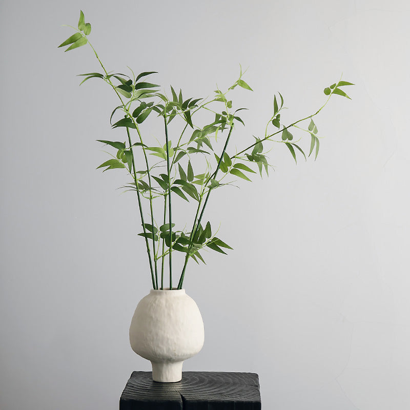Zen artificial bamboo plant in ivory ceramic vase styled in a minimalist home corner for calm interior decor